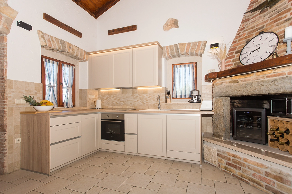 Beautiful white kitchen with a stone display cabinet and wine racks.